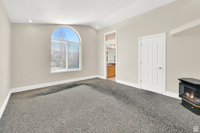 338 N 1090 W, Hyrum, UT 84319 - unfurnished bedroom featuring carpet floors, a wood stove, vaulted ceiling, baseboards, and ensuite bathroom