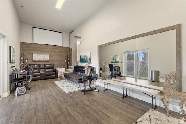 living room with a towering ceiling and wood finished floors
