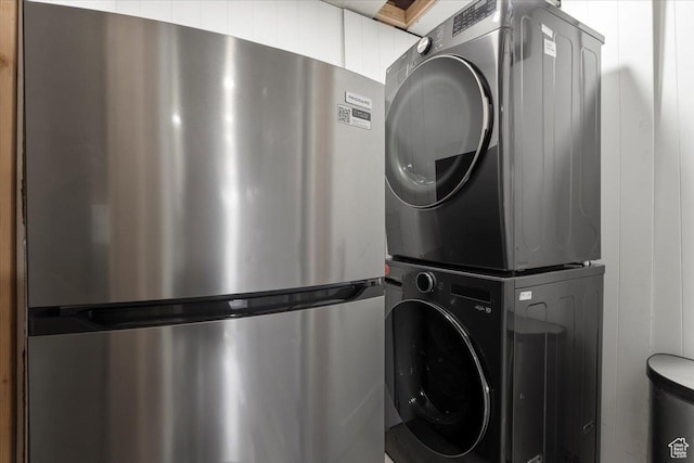 laundry area with stacked washer / drying machine and laundry area