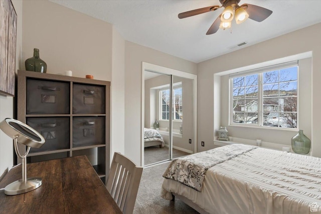 bedroom featuring a closet, carpet flooring, visible vents, and multiple windows