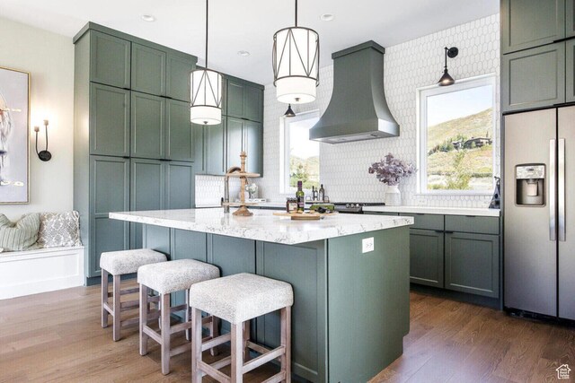 386 W Ascent Dr Unit 257, Hideout, UT 84036 - kitchen with dark wood-type flooring, green cabinets, light stone countertops, wall chimney exhaust hood, and stainless steel fridge