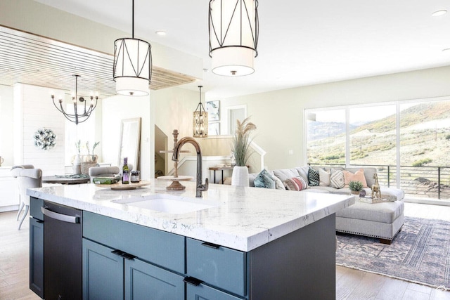 386 W Ascent Dr Unit 257, Hideout, UT 84036 - kitchen with stainless steel dishwasher, light wood-style floors, open floor plan, a sink, and light stone countertops