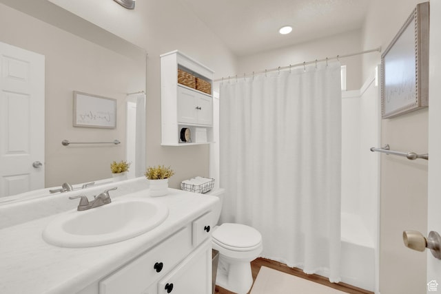 full bathroom with wood finished floors, vanity, toilet, and shower / tub combo
