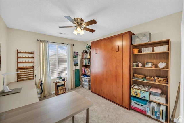 office featuring a ceiling fan, visible vents, and light colored carpet