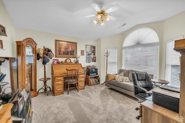 home office with ceiling fan, vaulted ceiling, a wealth of natural light, and light colored carpet