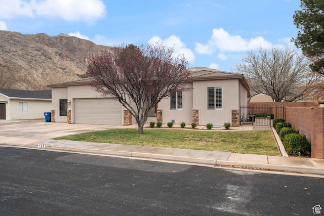 view of front of property with an attached garage, fence, concrete driveway, stucco siding, and a gate