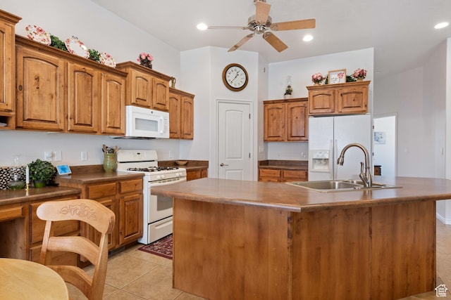 155 W 960 S, Hurricane, UT 84737 - kitchen featuring white appliances, brown cabinetry, light tile patterned flooring, a sink, and a center island with sink