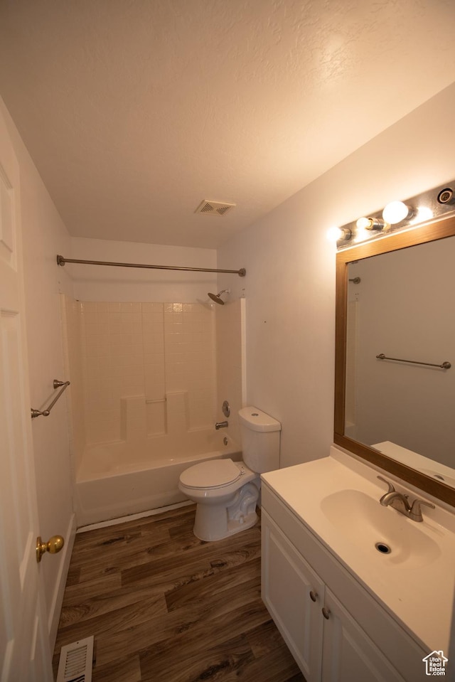 full bathroom with wood finished floors, visible vents, toilet, vanity, and shower / bathtub combination