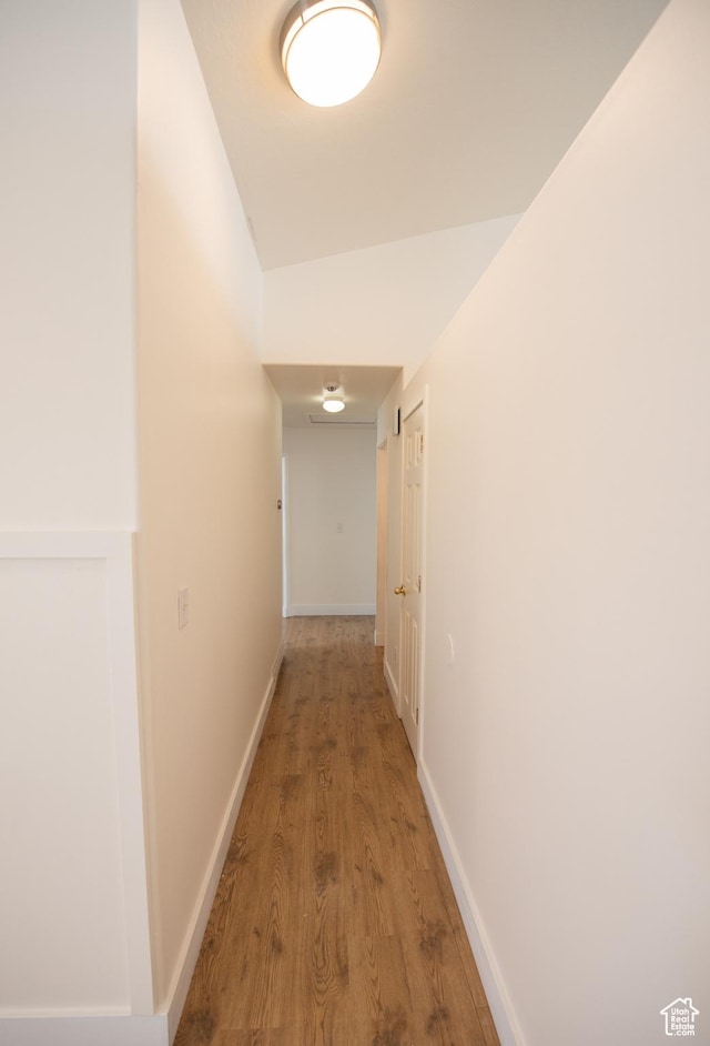 hallway featuring baseboards and wood finished floors