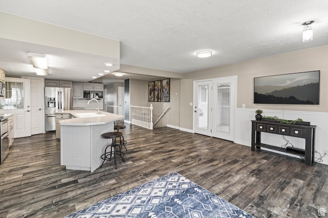 79 S 250 E, Aurora, UT 84620 - kitchen featuring dark wood finished floors, stainless steel appliances, a textured ceiling, light countertops, and a sink