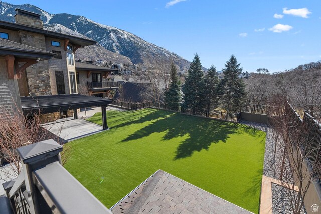 view of yard with a patio, a balcony, a fenced backyard, and a mountain view