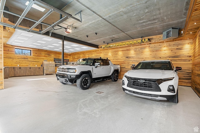garage with wood walls and a garage door opener