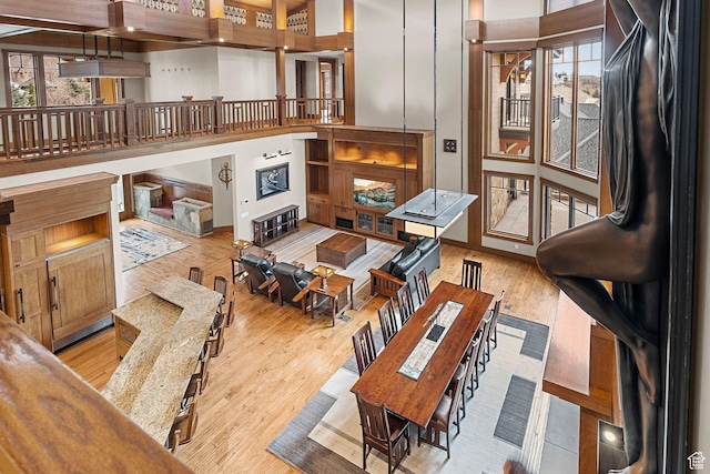 interior space featuring a fireplace, stairs, wood finished floors, and a towering ceiling