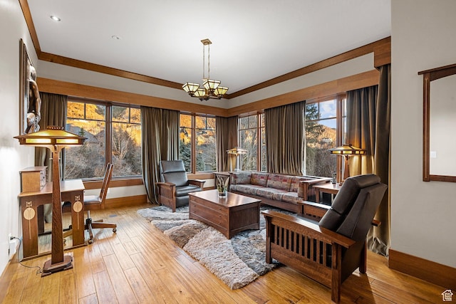 living area featuring a notable chandelier, baseboards, and light wood-type flooring
