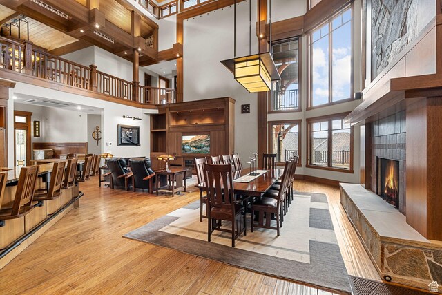 dining area with a high ceiling, wood finished floors, and a fireplace
