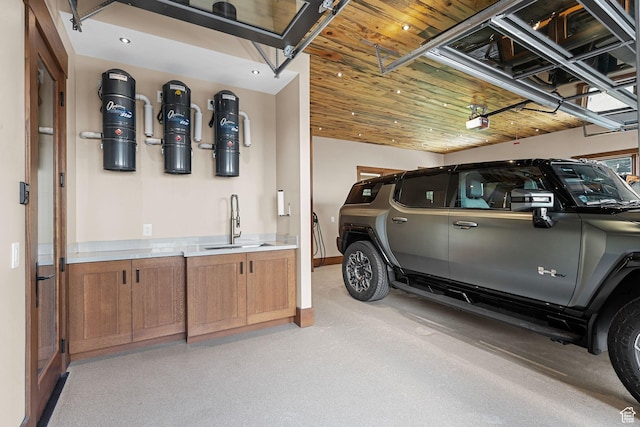 garage featuring a sink, wooden ceiling, a garage door opener, and recessed lighting