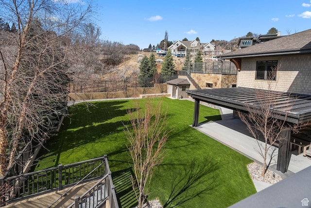 view of yard with an outbuilding, a patio, and fence