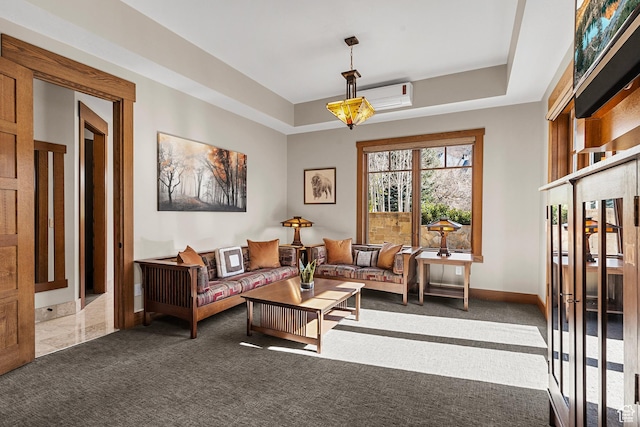 sitting room featuring a tray ceiling, baseboards, carpet flooring, and a wall unit AC