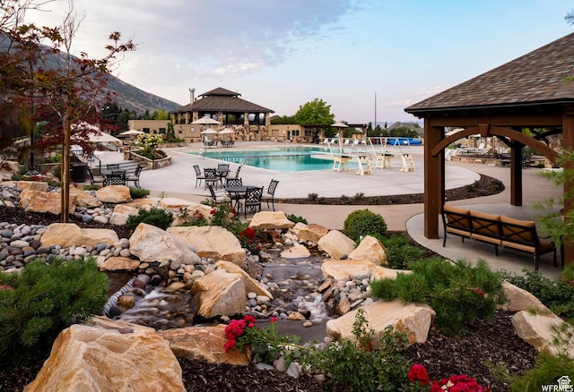 community pool with a gazebo and a patio area