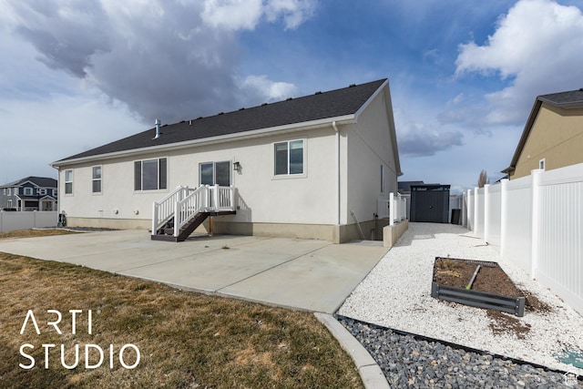 rear view of house featuring a patio, stucco siding, a fenced backyard, and a shingled roof