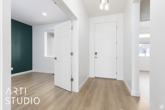 hallway with baseboards and light wood-style flooring