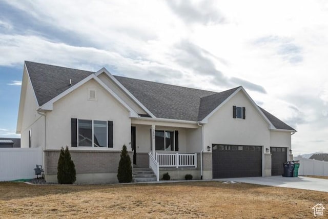 view of front of house featuring fence, covered porch, driveway, and stucco siding