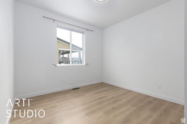 spare room with light wood-type flooring, baseboards, and visible vents