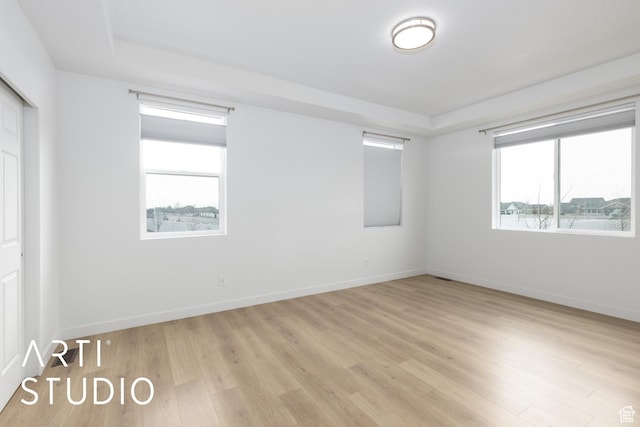 unfurnished room with baseboards and light wood-style flooring