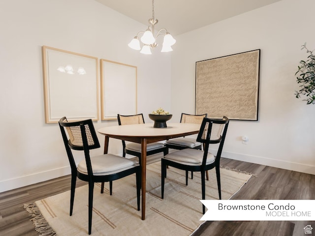 dining room featuring a notable chandelier, baseboards, and wood finished floors