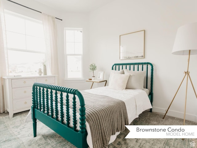 bedroom featuring light colored carpet and baseboards