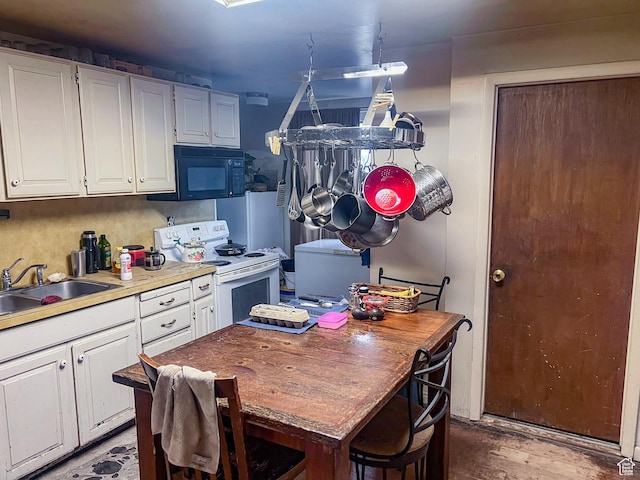 kitchen featuring electric range, a sink, white cabinetry, and black microwave