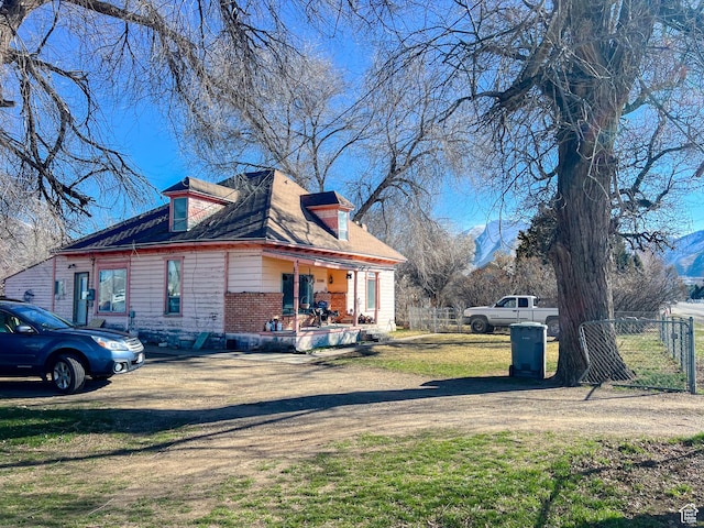 view of side of property with fence, brick siding, and a yard
