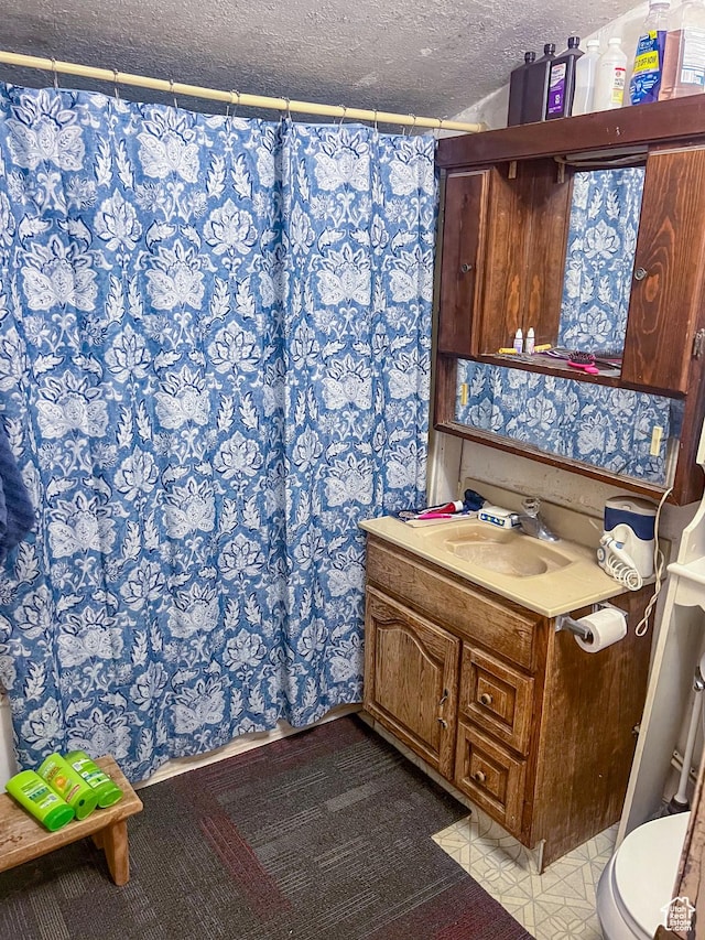full bath with a shower with curtain, toilet, vanity, and a textured ceiling