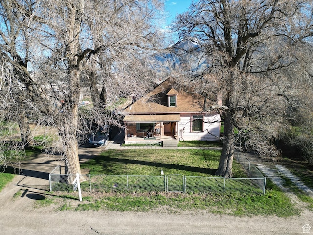 view of front facade with dirt driveway, a fenced front yard, and a front yard