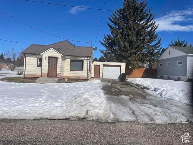 161 E 4th S, Soda Springs, ID 83276 - view of front of property with an outbuilding, metal roof, a detached garage, and fence
