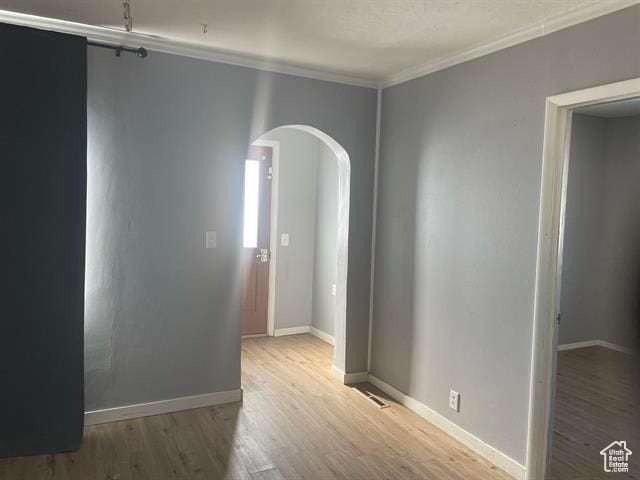 161 E 4th S, Soda Springs, ID 83276 - unfurnished room with baseboards, crown molding, arched walkways, and wood finished floors
