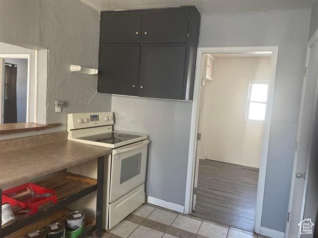 161 E 4th S, Soda Springs, ID 83276 - kitchen with white electric range oven, light tile patterned floors, baseboards, and a textured wall