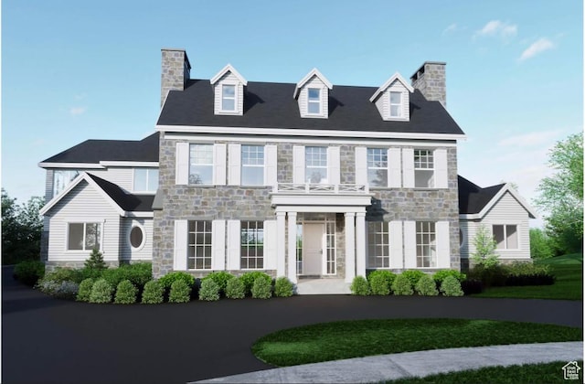 colonial inspired home featuring stone siding and a chimney