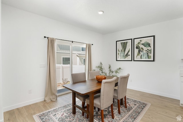 dining area featuring light wood-style floors and baseboards