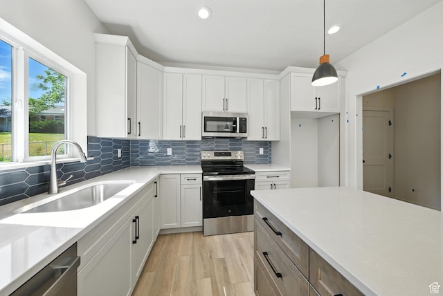 4068 S Porter Ave, South Ogden, UT 84403 - kitchen with stainless steel appliances, decorative backsplash, light countertops, recessed lighting, and hanging light fixtures