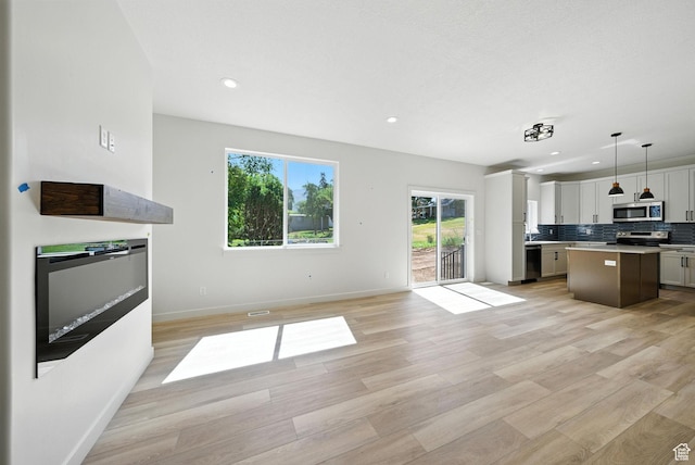 4068 S Porter Ave, South Ogden, UT 84403 - kitchen featuring appliances with stainless steel finishes, open floor plan, a kitchen island, light wood-style floors, and recessed lighting