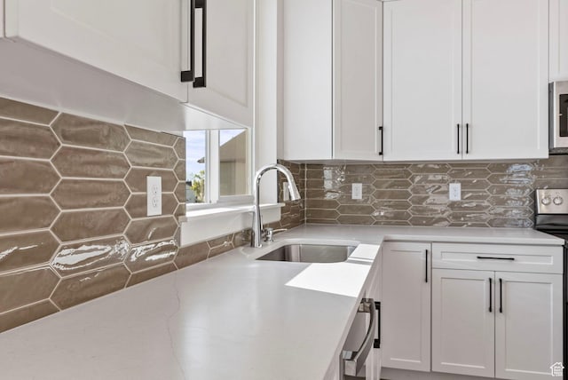4068 Porter Ave, South Ogden, UT 84403 - kitchen featuring a sink, white cabinetry, stainless steel microwave, tasteful backsplash, and range