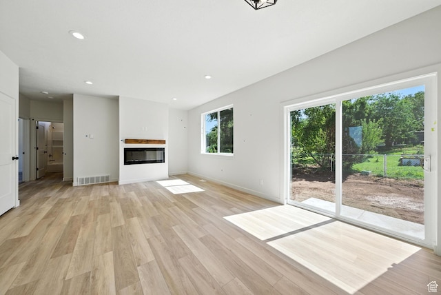 4068 S Porter Ave, South Ogden, UT 84403 - unfurnished living room with light wood finished floors, a glass covered fireplace, and recessed lighting