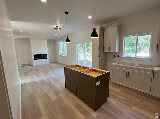 4068 Porter Ave, South Ogden, UT 84403 - kitchen with light wood finished floors, recessed lighting, decorative light fixtures, a glass covered fireplace, and a center island