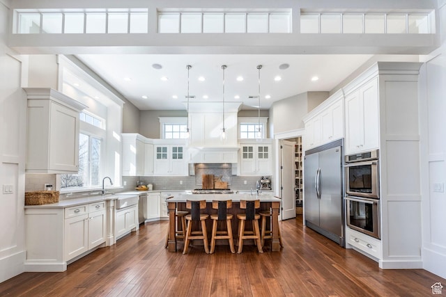 884 E Fence Post Rd S, Fruit Heights, UT 84037 - kitchen featuring stainless steel appliances, a breakfast bar, dark wood-type flooring, decorative backsplash, and glass insert cabinets