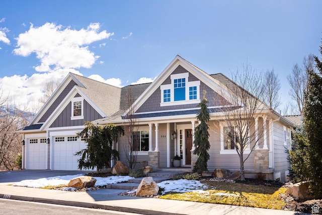 craftsman house featuring covered porch, driveway, and board and batten siding