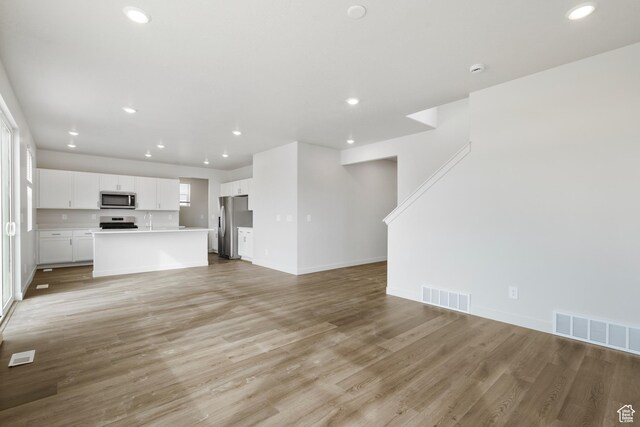 3537 S 3150 W Unit 106, West Haven, UT 84401 - unfurnished living room with visible vents and light wood-style flooring