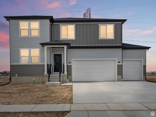 view of front facade featuring board and batten siding, driveway, and a garage