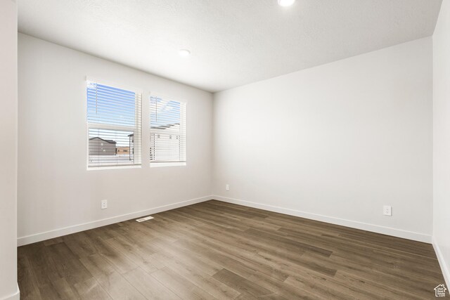 3537 S 3150 W Unit 106, West Haven, UT 84401 - spare room with baseboards, dark wood-style floors, and visible vents