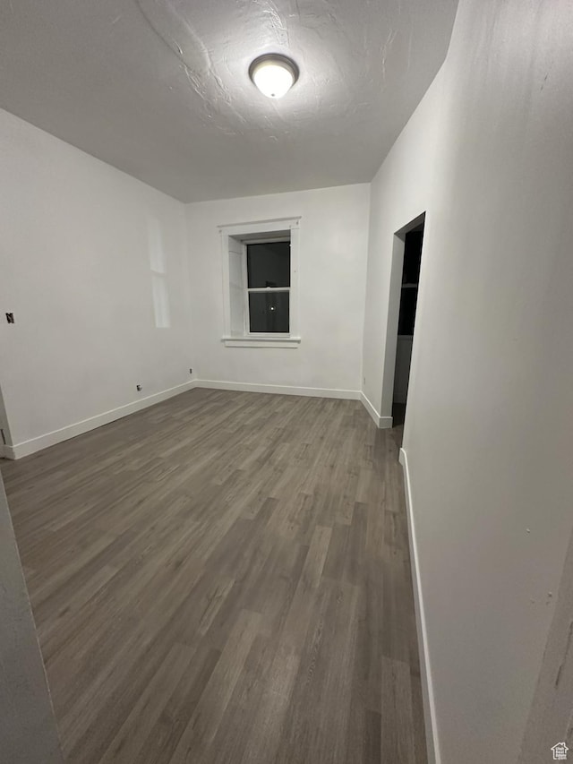 spare room featuring wood finished floors and baseboards